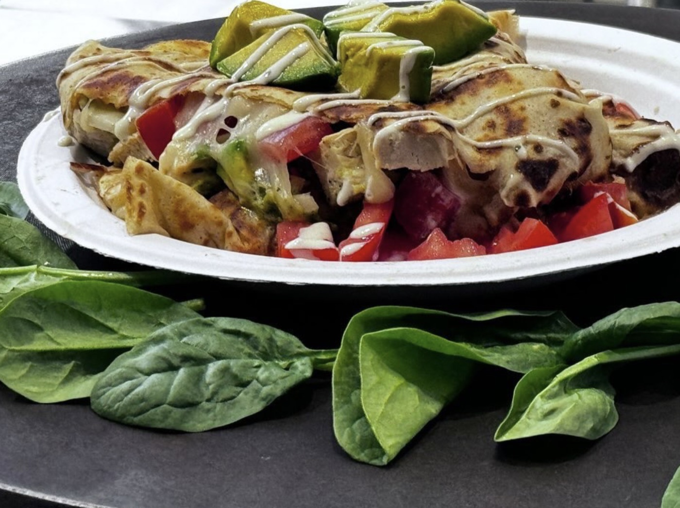 Savory chicken crepe with avocado, tomato and cream drizzle