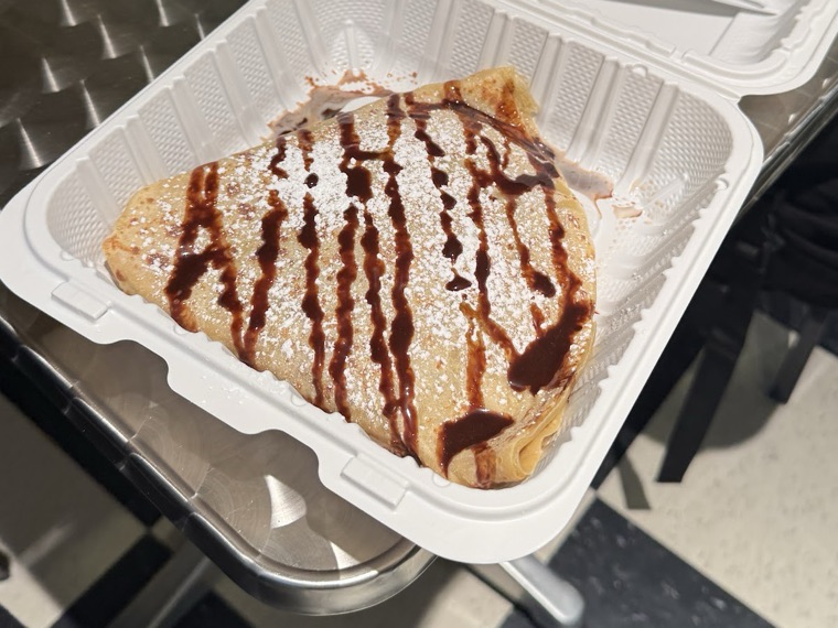 Photo from Minul Mirdha's Google review — folded crepe with chocolate drizzle and powdered sugar