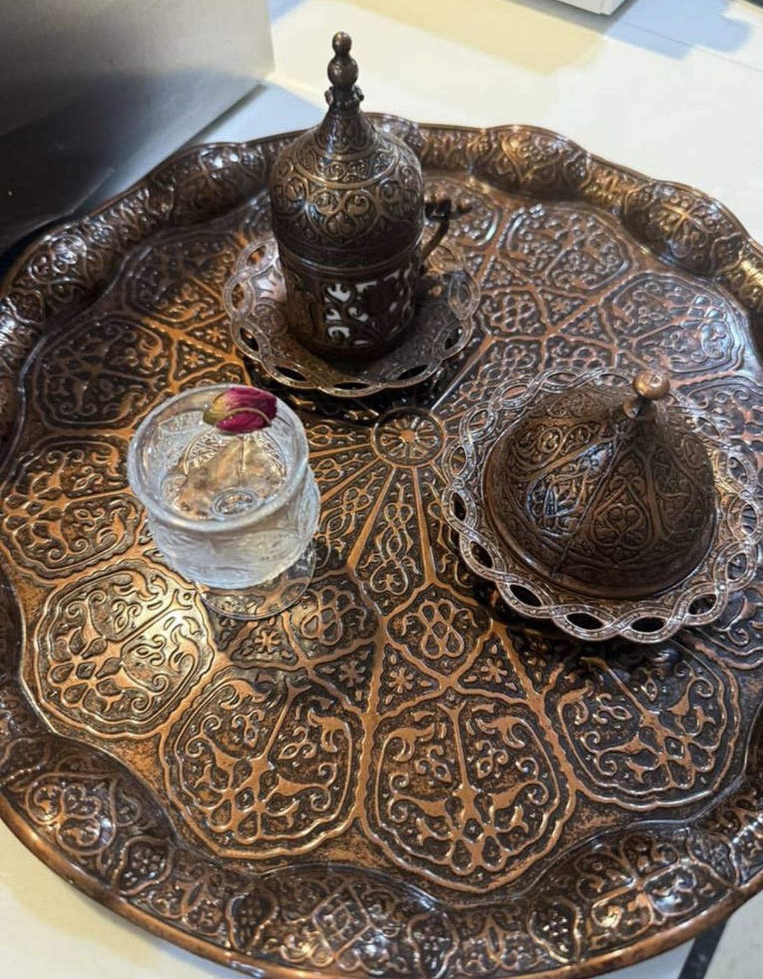 Turkish coffee served on an ornate copper tray with rose water